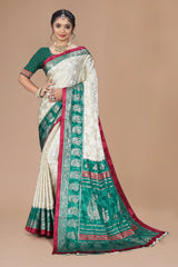 Woman wearing a traditional saree with green and red patterns on a beige background