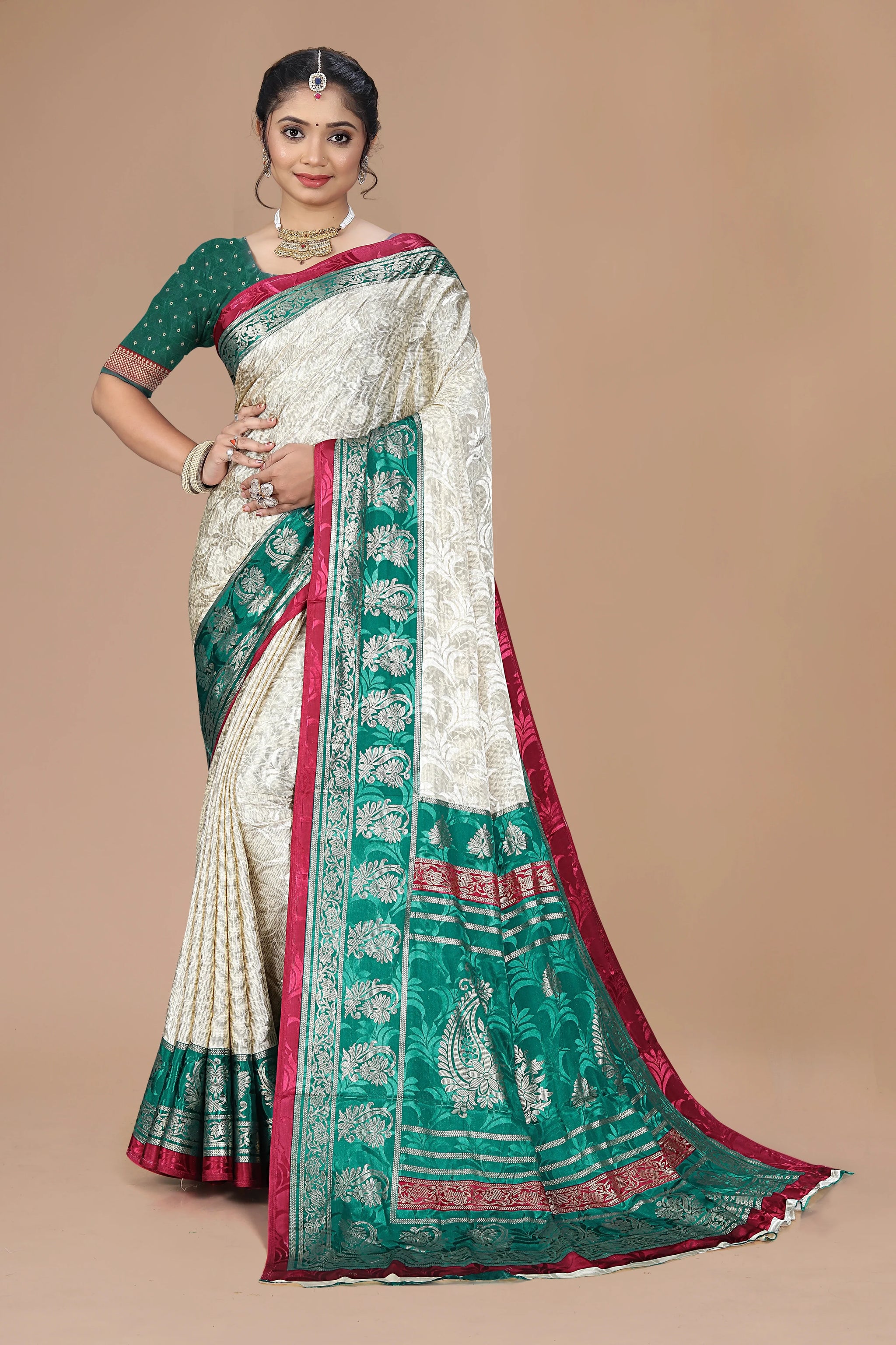 Woman wearing a traditional saree with green and red patterns on a beige background